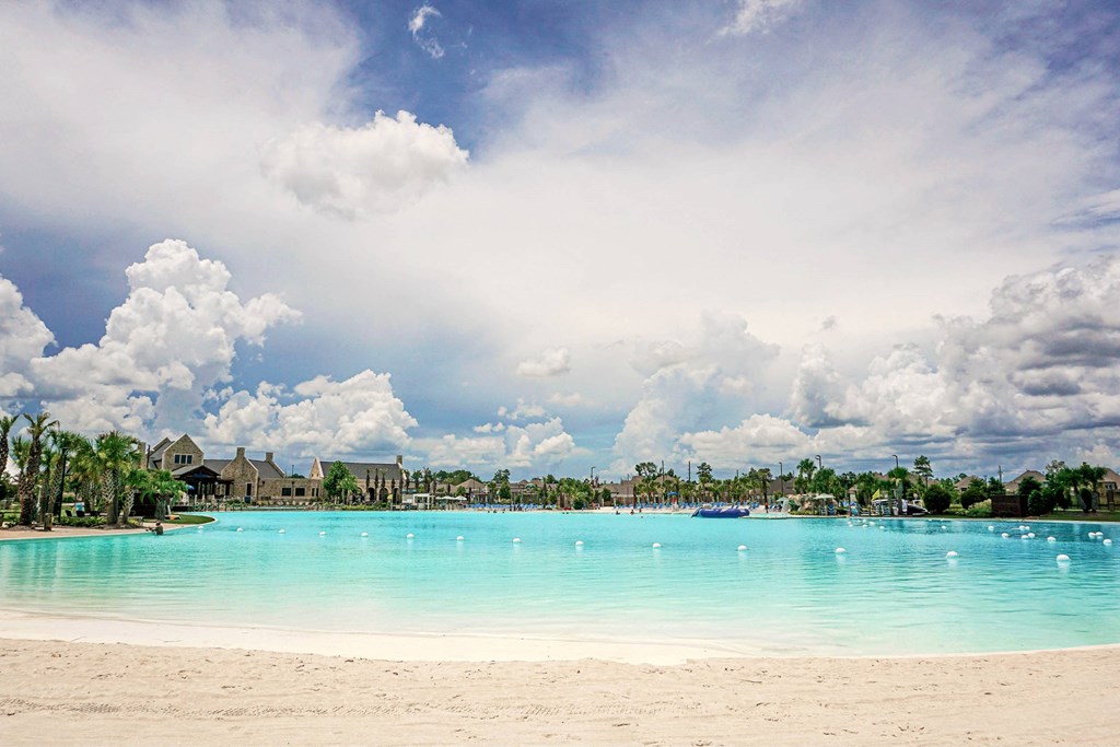 A beautiful beach with a clear blue sky and white clouds.