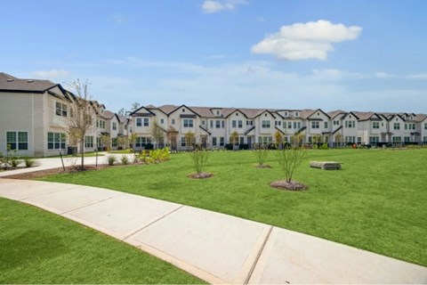 A row of houses with a grassy front yard.