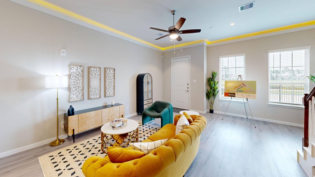 A living room with a yellow sofa and a black and white rug.