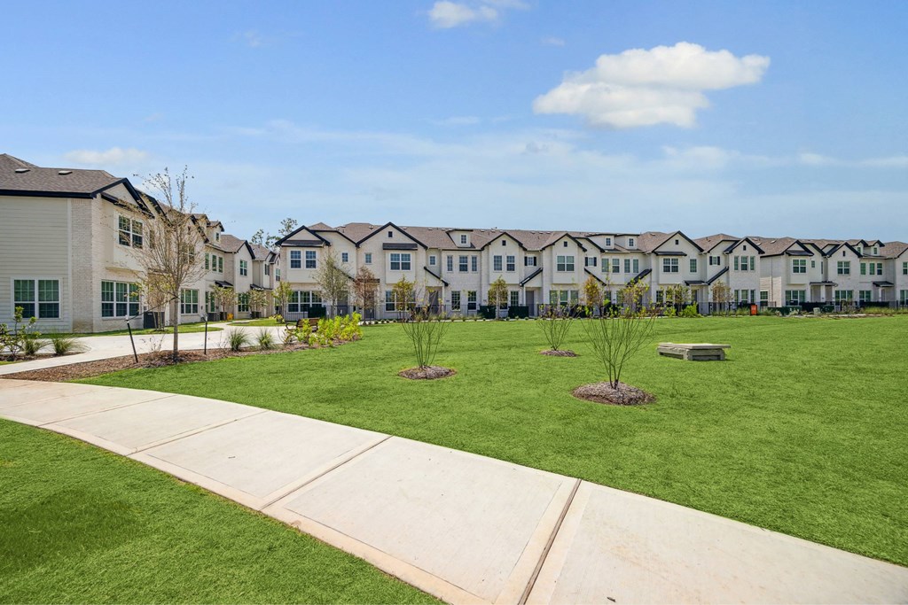 A row of houses with a green lawn in front.