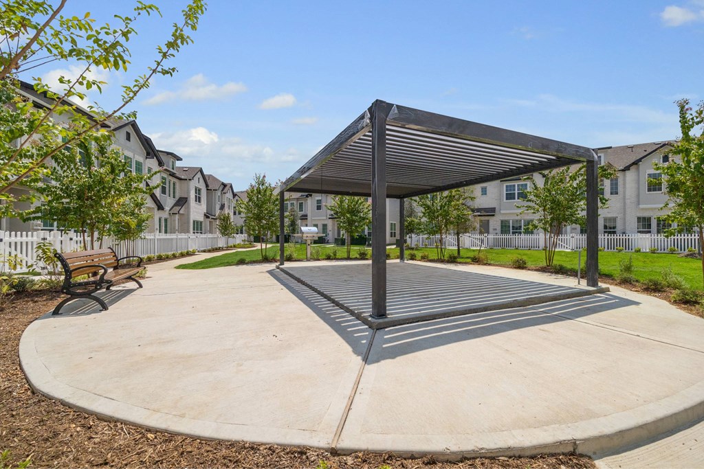 A playground with a black canopy and a grey ground.