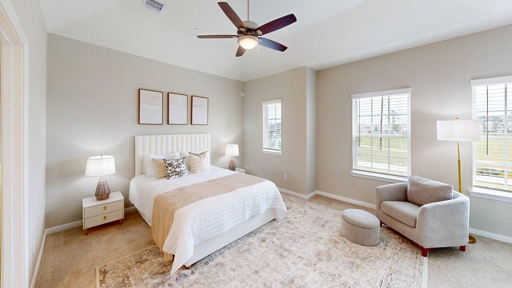 A bedroom with a large bed and a ceiling fan.