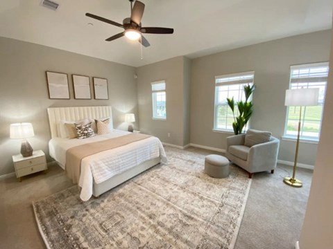 A bedroom with a large bed and a ceiling fan.