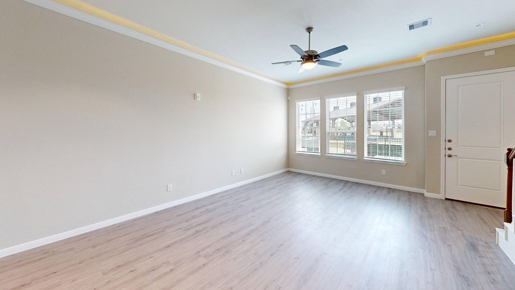 A room with a ceiling fan and a door.