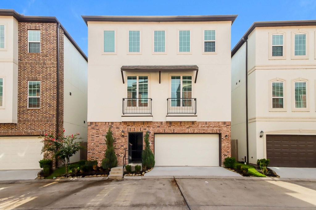 A row of houses with garages and balconies.
