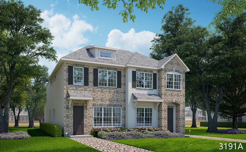 A house with a grey roof and a stone wall is surrounded by greenery.