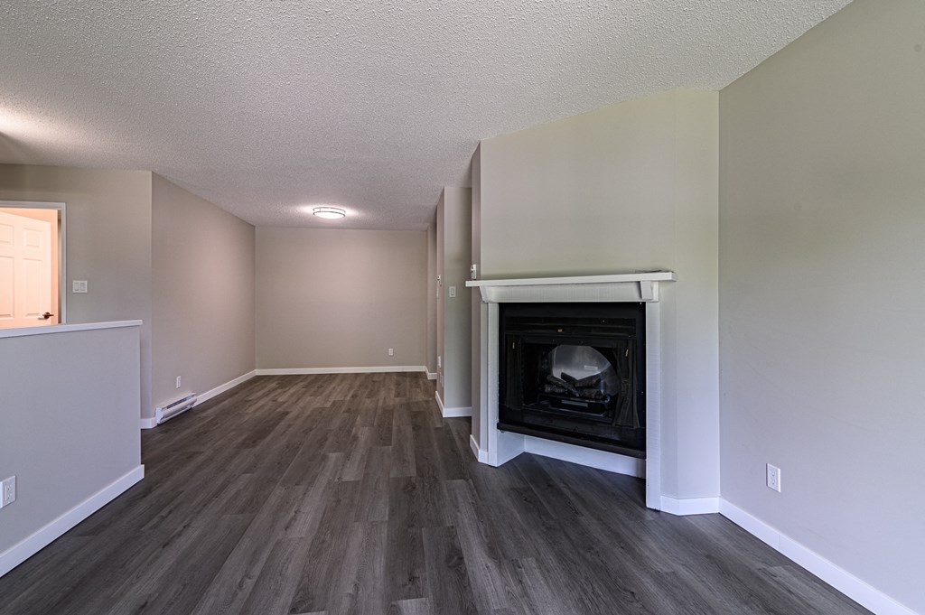 a living room with a fireplace and hardwood floors
