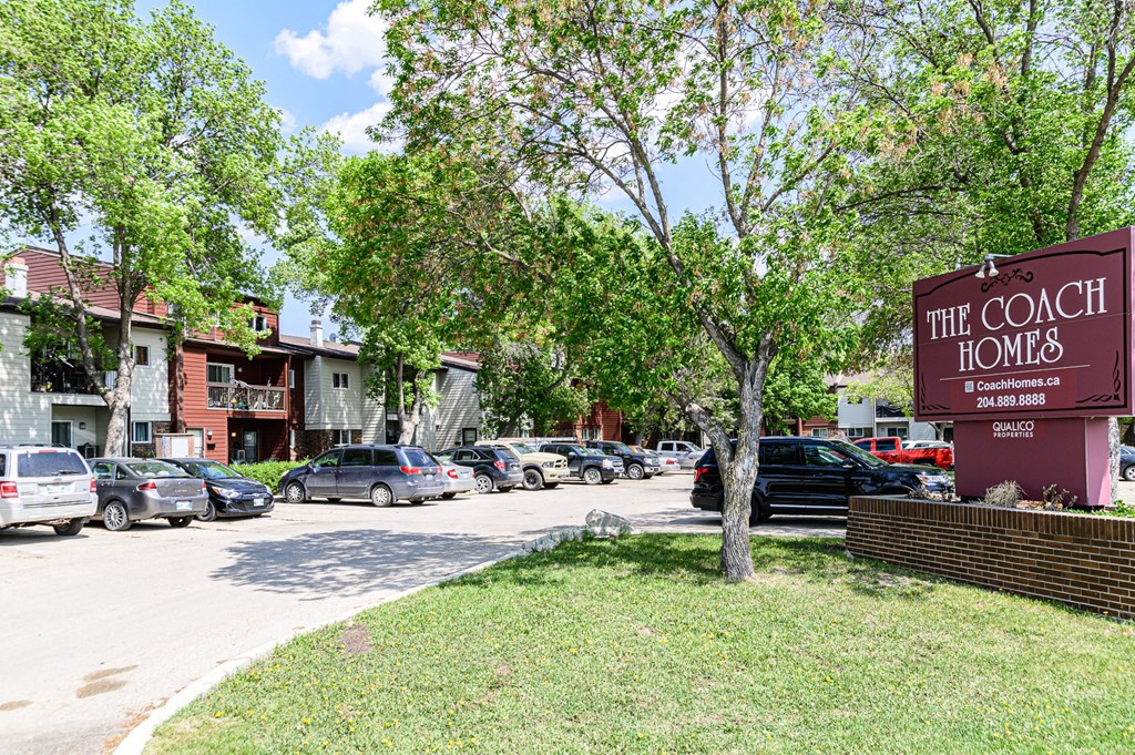 a parking lot with a sign that reads the coach home