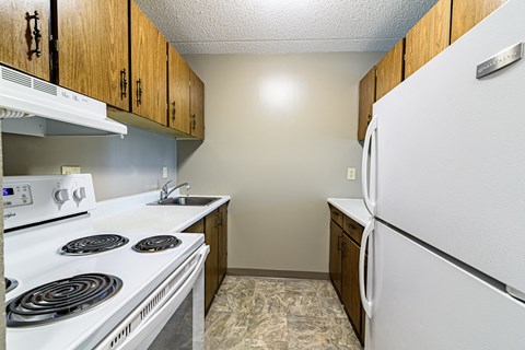 a kitchen with white appliances and wood cabinets