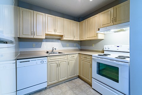 a kitchen with white appliances and wooden cabinets