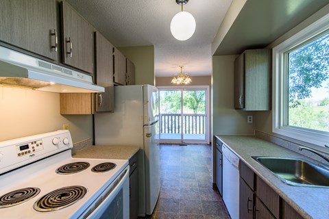 the view of a kitchen with a stove and a refrigerator