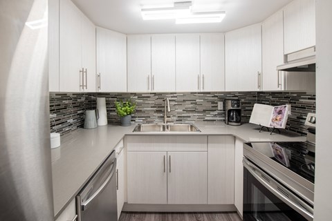 a kitchen with white cabinets and a sink and counter top