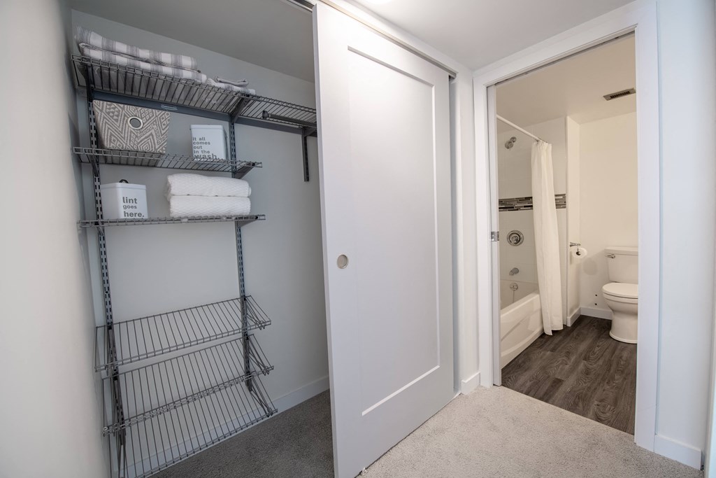 a bathroom with a closet and a toilet and a shower