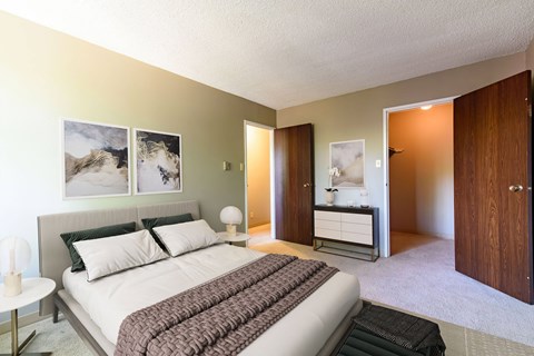 a bedroom with a bed and a sink and a mirror