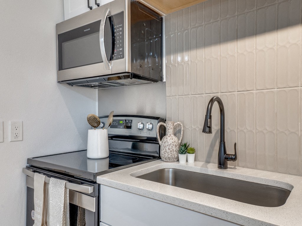 a kitchen with a sink and stove and a microwave