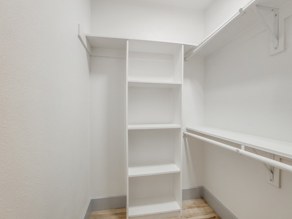 a room with white shelves and a white closet