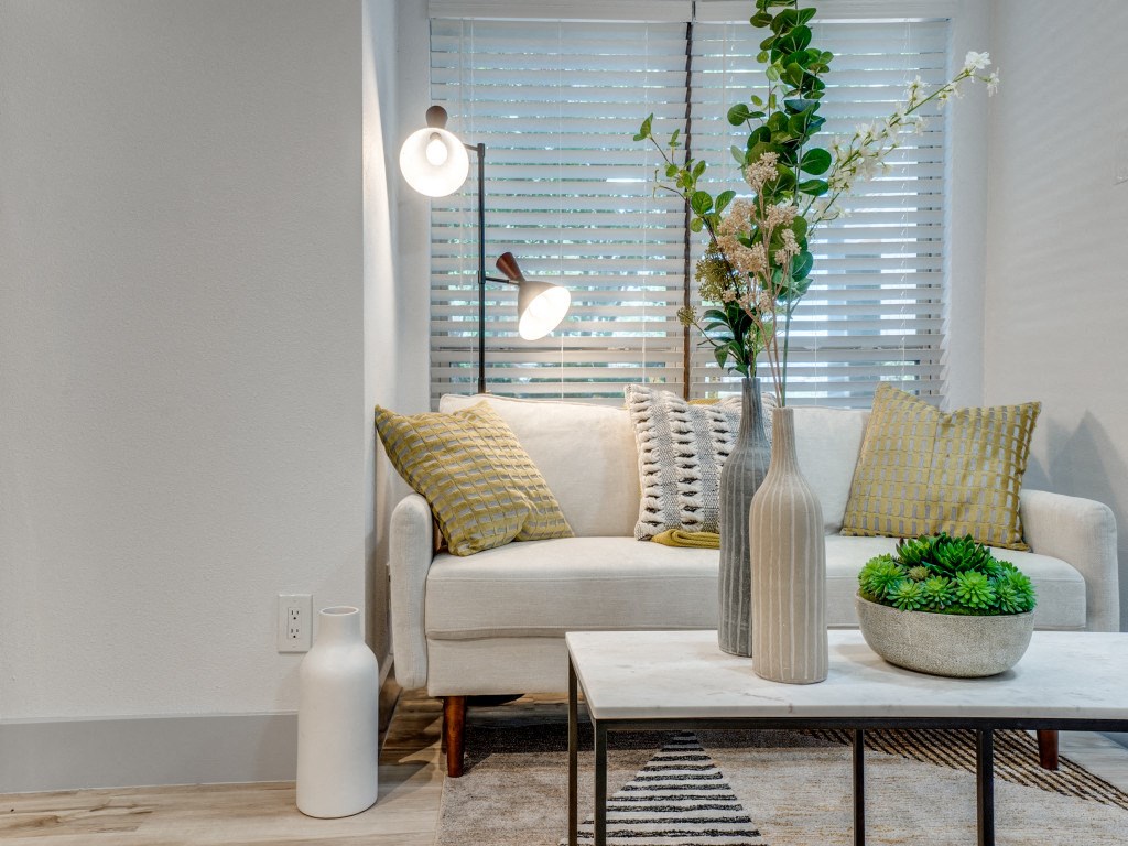 a living room with a couch and a table with a vase