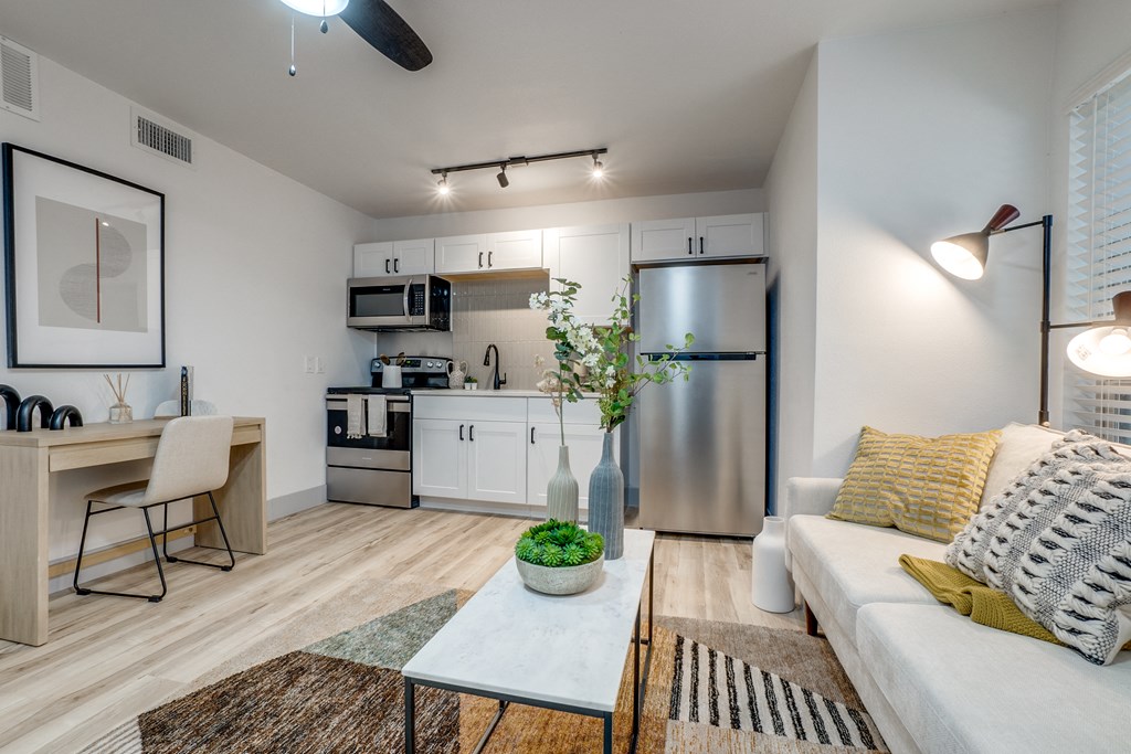 a living room with a couch and a coffee table and a kitchen