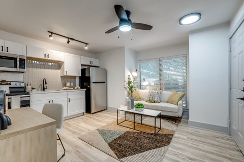 a living room and kitchen with a couch and a table