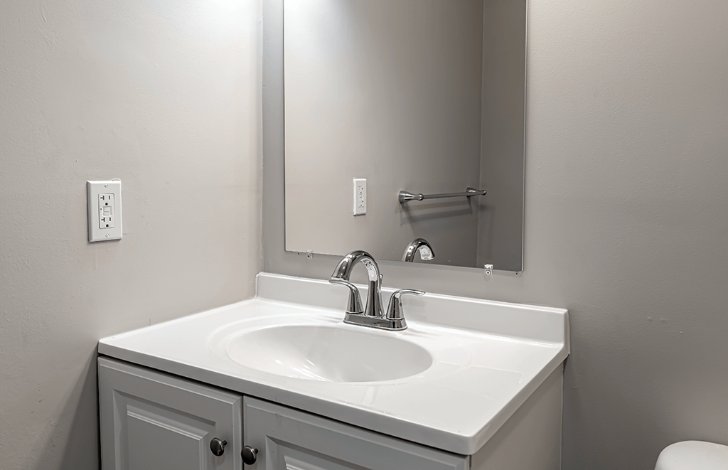 an empty bathroom with a sink and a mirror