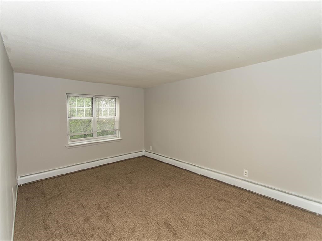 an empty room with carpet and a window
