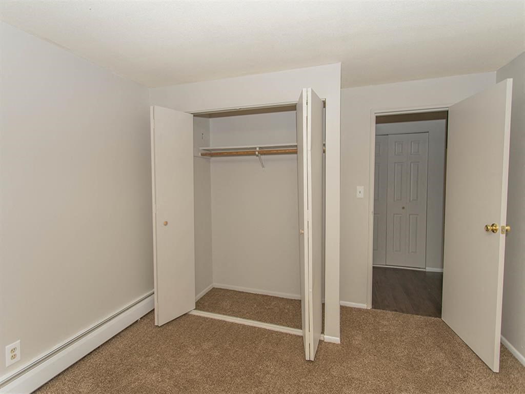 a bedroom with a closet and a door to a hallway