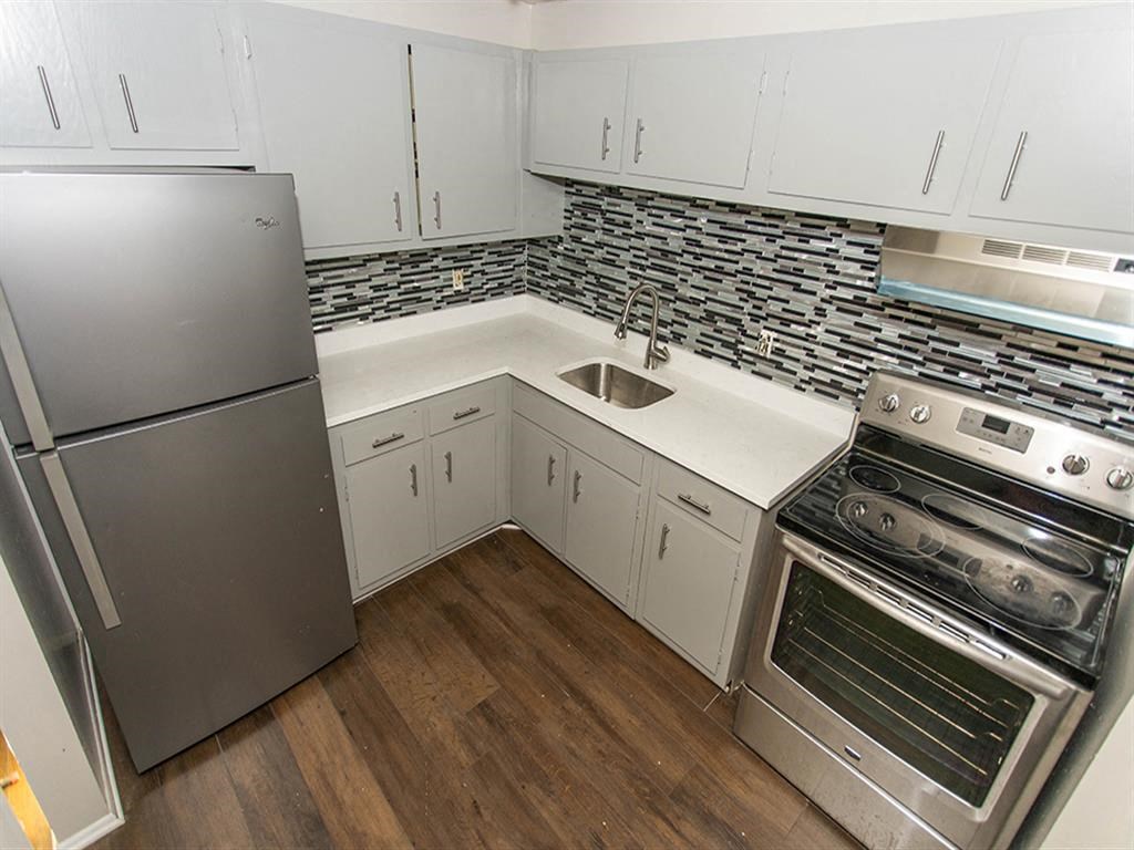 a kitchen with white cabinets and stainless steel appliances