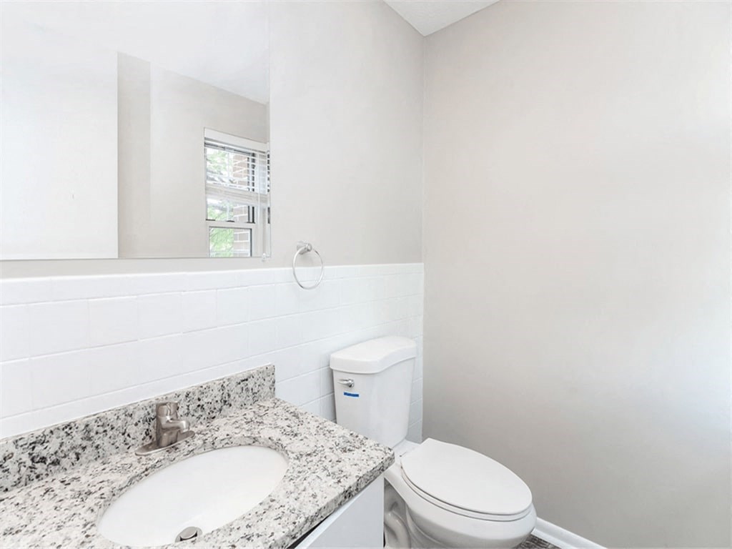 a bathroom with a toilet and a sink and a mirror