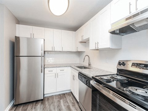 a kitchen with stainless steel appliances and white cabinets