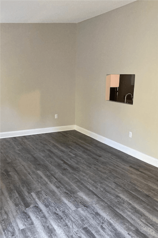 an empty living room with wood flooring and a fireplace