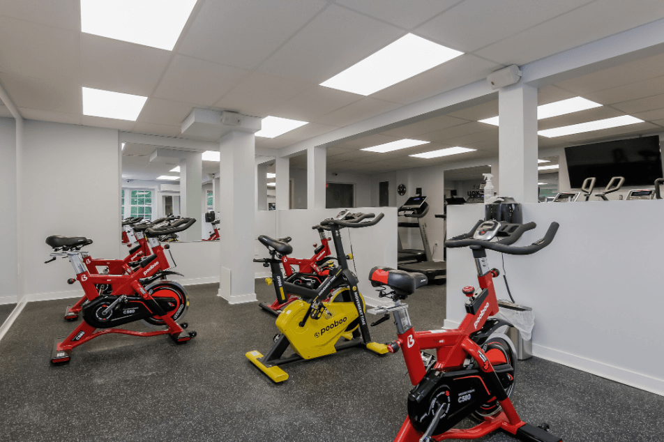 an indoor gym with bikes and stationary bikes on the floor