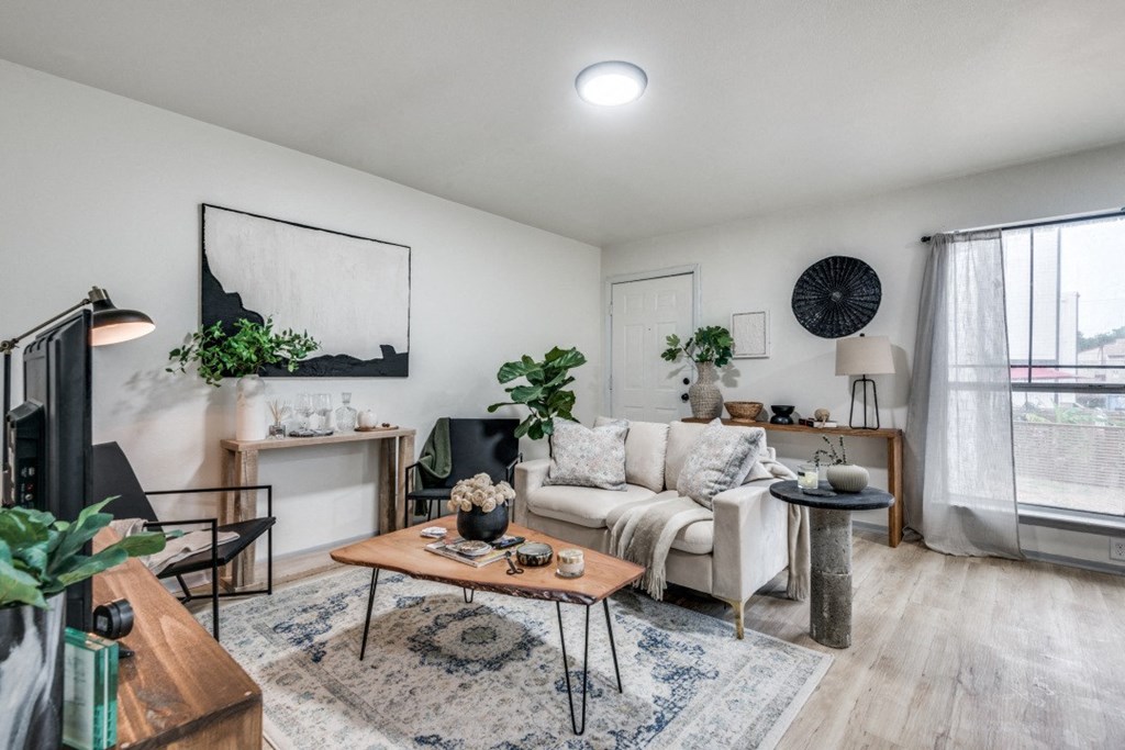 a living room with white walls and hardwood floors