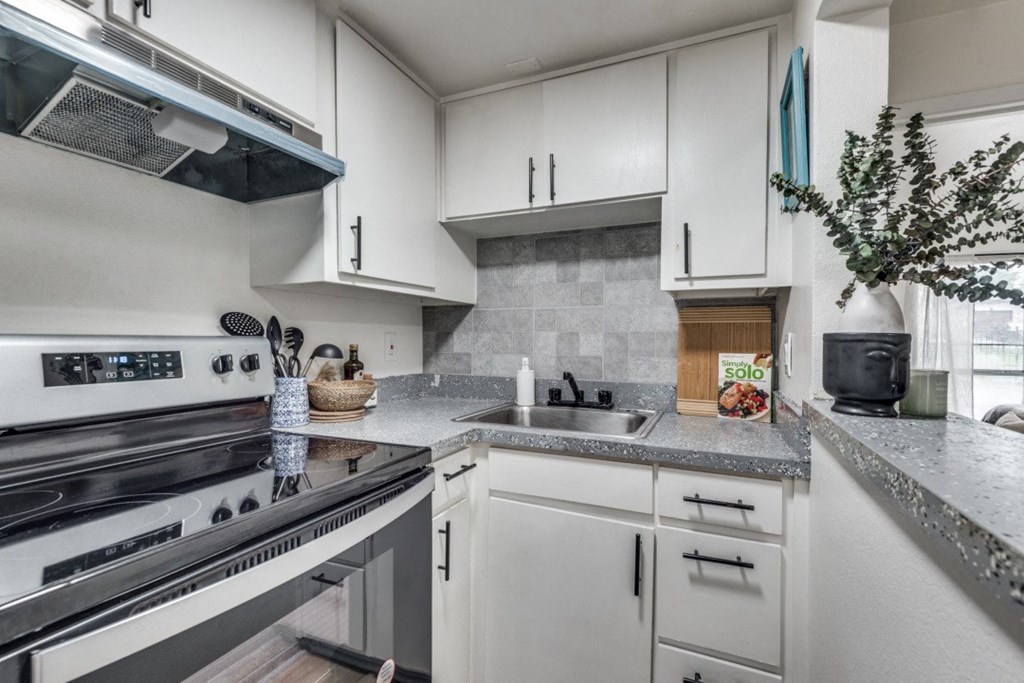 a kitchen with white cabinets and stainless steel appliances