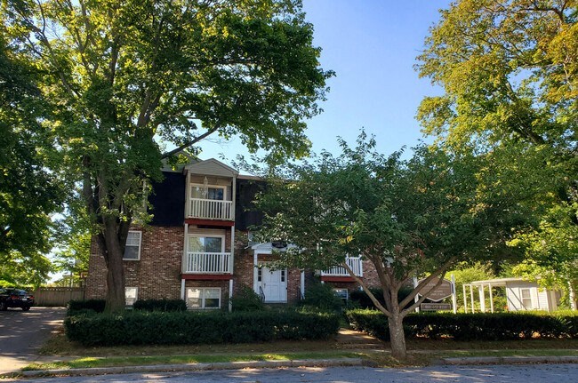 a brick apartment building with trees in front of it