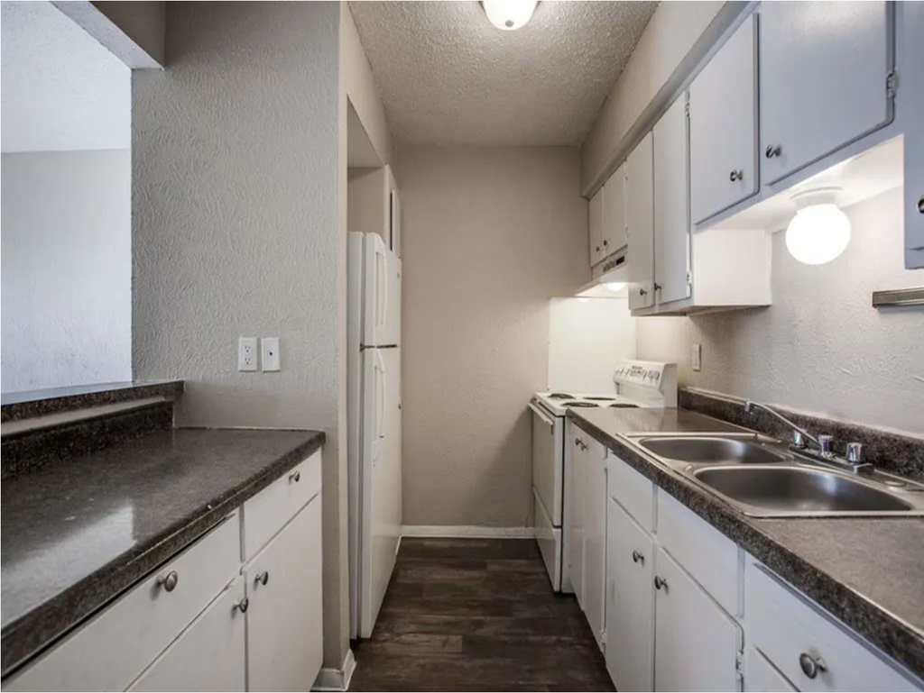 a kitchen with white cabinets and granite counter tops