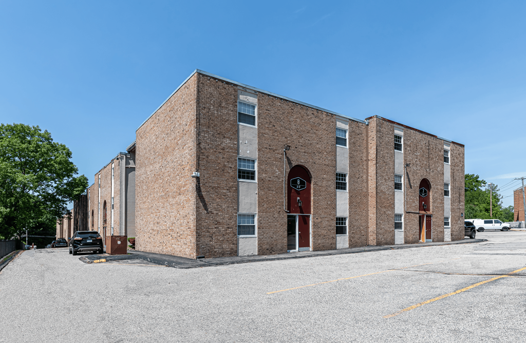 a brick building with two doors and a parking lot