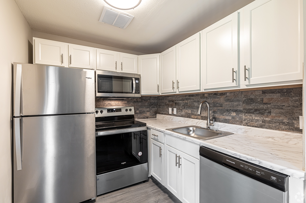 a kitchen with stainless steel appliances and white cabinets