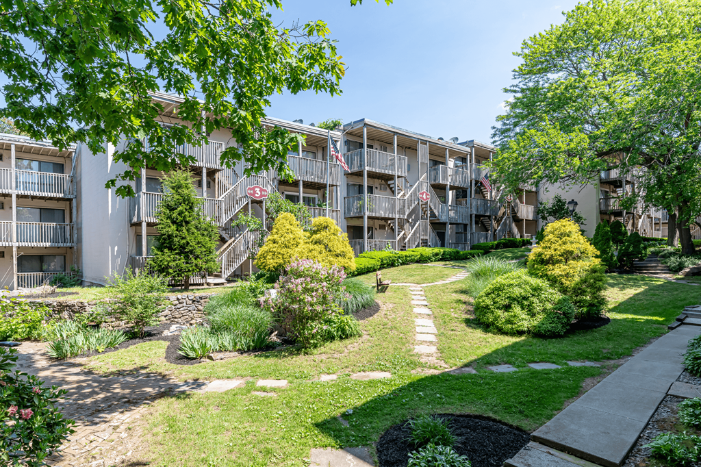 an exterior view of an apartment building with a landscaped courtyard