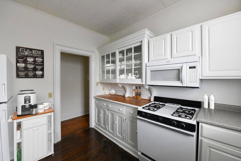a kitchen with white cabinets and a stove and a microwave