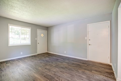 A room with a window and two doors.