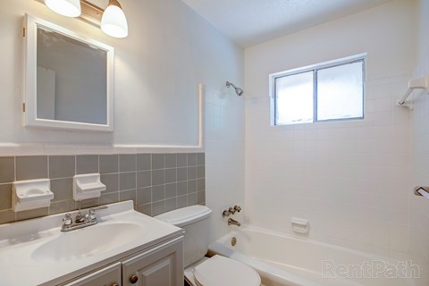 A white bathroom with a sink, toilet, and bathtub.