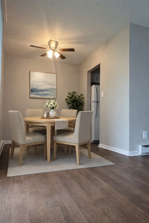 A dining room with a table and chairs.