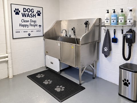 A dog wash station with a sign that says "Dog Wash Clean Dogs Happy People".