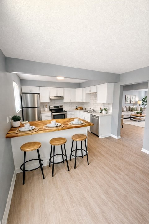 A kitchen with a bar stool and a counter with plates on it.