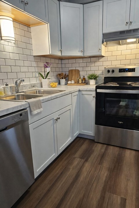 A kitchen with white cabinets and a stainless steel dishwasher.