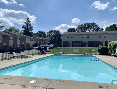 A pool surrounded by apartment buildings and a "No Diving" sign.