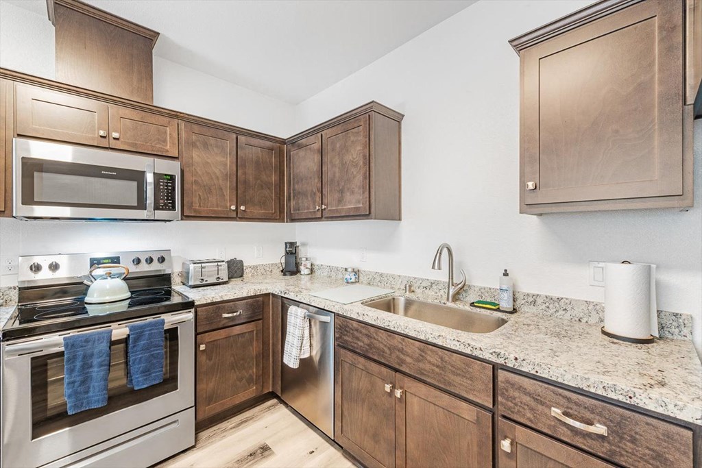 a kitchen with wooden cabinets and stainless steel appliances