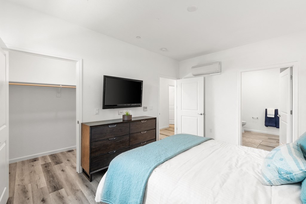 a bedroom with a large bed and a tv on the wall