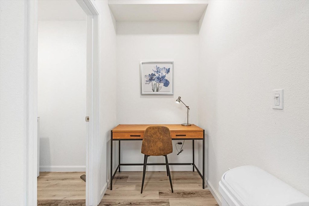 a bedroom with a desk with a chair and a bed