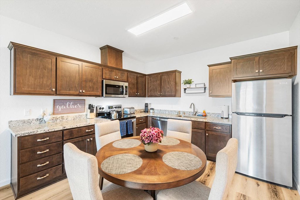 a kitchen with stainless steel appliances and a wooden table